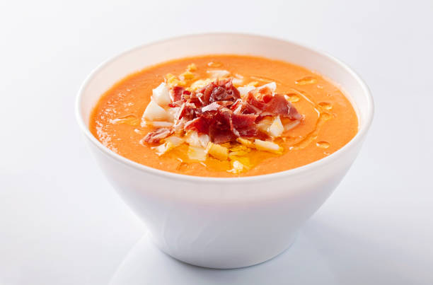 Salmorejo soup with serrano ham and boiled egg on white background