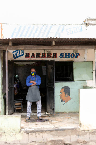 istock Vertical portrait barber wearing mask and apron outside store front 1364574829