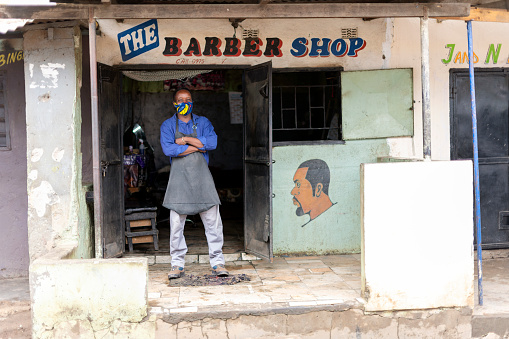 Vertical portrait with copy space African barber with mask ready for business