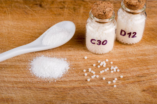 istock Homeopathy globules in glas bottles on a table with spoon and powder 1364577422