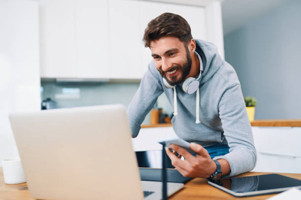 istock Ux designer leaning on desk and checking work on laptop and smartphone 1364578626