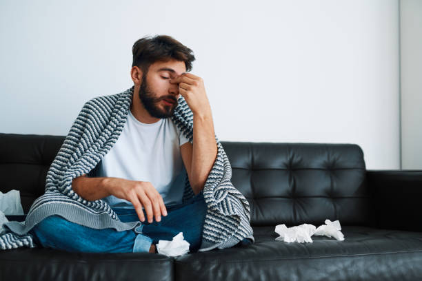 istock Man suffering sinusitis sitting on couch at home having headache 1364578668