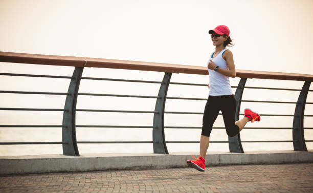 istock Fitness woman runner running on seaside bridge 1364580754