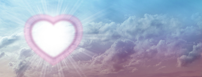 a large empty triple border illuminated  heart creating a frame on left side of blue pink sky background with copy space for messages