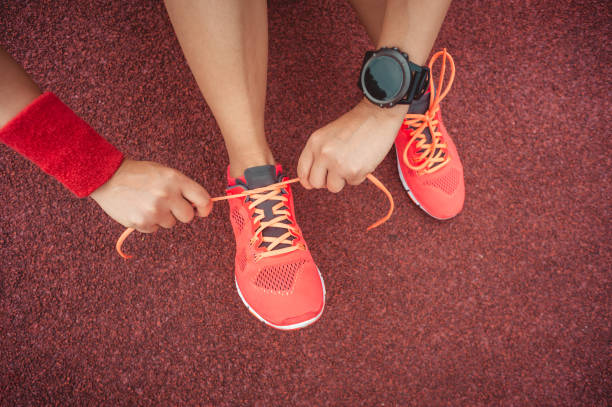 istock Young woman runner tying shoelaces on tracks 1364582921