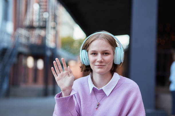 istock Happy woman looking at web camera waving hand and greeting. 1364585790