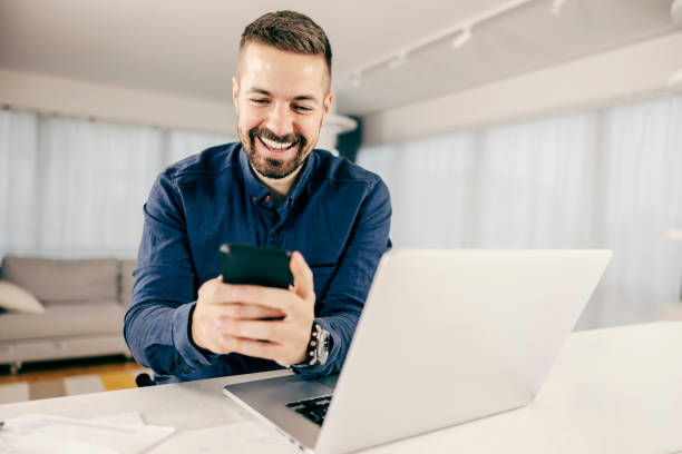 istock A happy businessman using mobile phone and working online from home. 1364586404