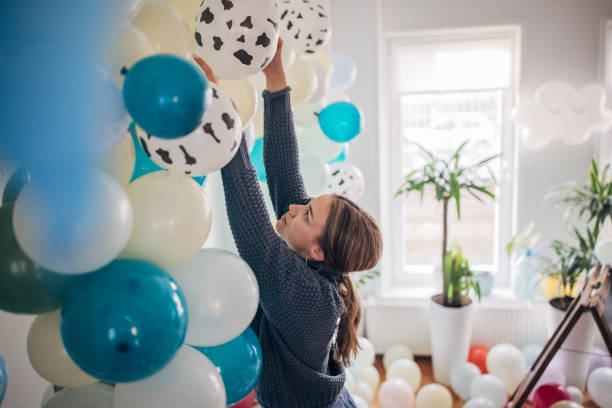 istock Young party planner arranging ballon decoration 1364587386