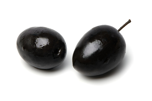 Black olives isolated on white background. Two black olives with pit. Clipping Path.