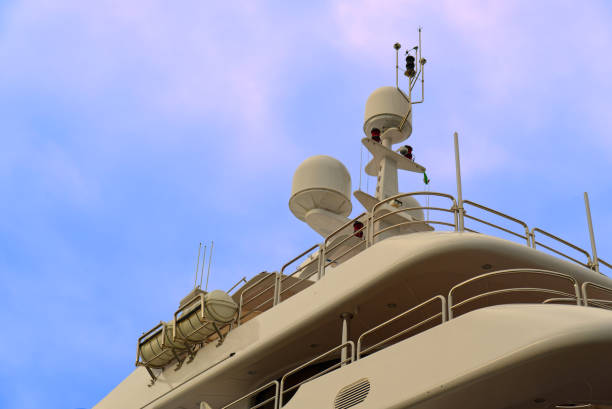 Detail of a luxury white yacht with navigation equipment, radar and antennas on blue sky, superstructure
