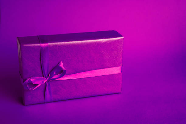 Banner with purple gift box on purple background for Christmas or Valentine's day. Copy space for your text.