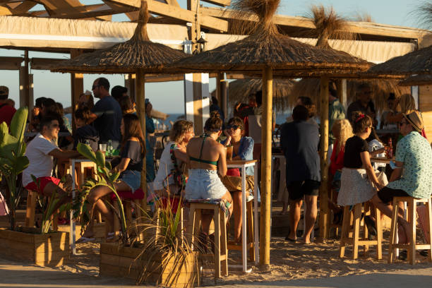 люди пьют пиво в пляжном баре chiringuito, испания - andalusia beach cadiz spain стоковые фото и изображения