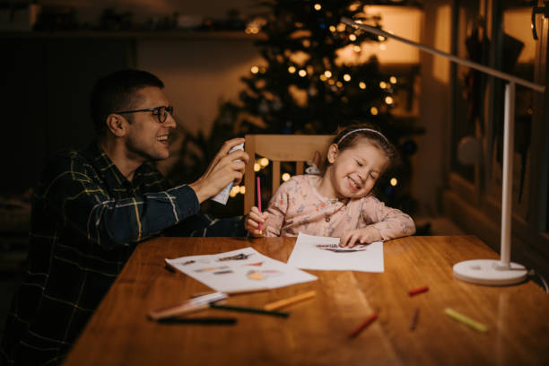 istock Father spraying nasal spray to his daughter's nose while she drawing 1364593757