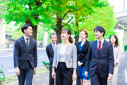 Business people walking outside with smiles on their faces