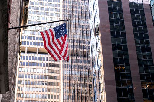 SA flag on Wall Street, Manhattan, New York City ,Office skyscraper Reflection in the sunlight. New York City
