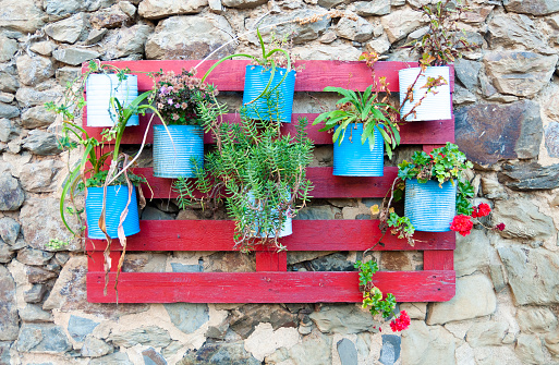 recycled wooden pallet used as a flowerpot, multicolor, rustic stone wall  2