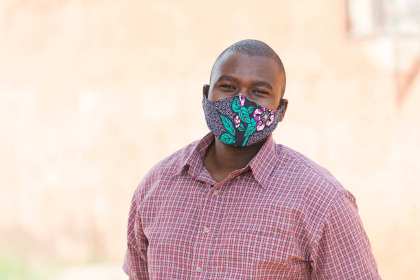 istock Portrait happy young African man wearing protective face mask 1364603434