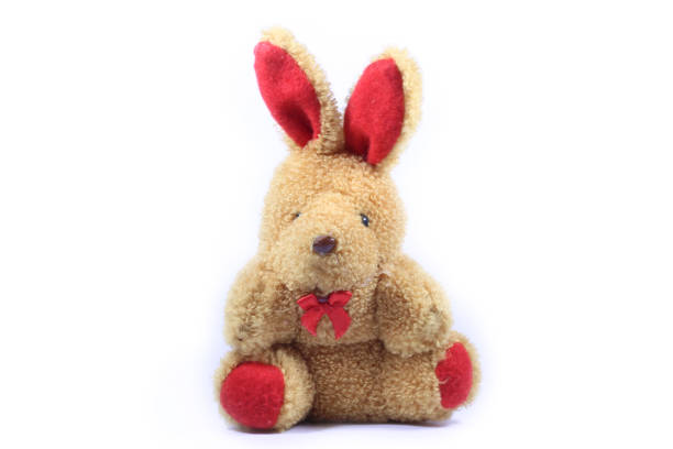 This image features an old, yet cute teddy bear wearing a gray scarf, lying on a white background. The bear shows signs of wear, emphasizing its history and beloved character. Concept for themes such as childhood memories, comfort, security, and nostalgia. Ideal for advertisements, articles about toys, nursery decoration, and blogs about childhood and memories