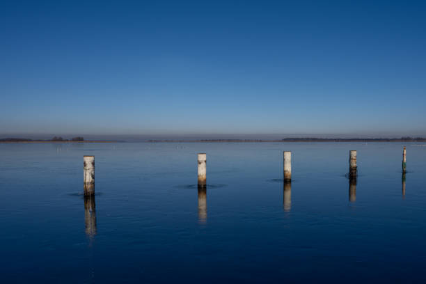 A view of empty docks in the winter. Blue water and a clear blue sky