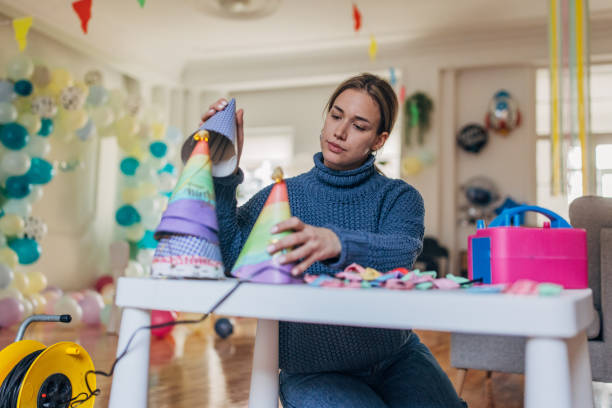 istock Party decorator making birthday party hats 1364606558