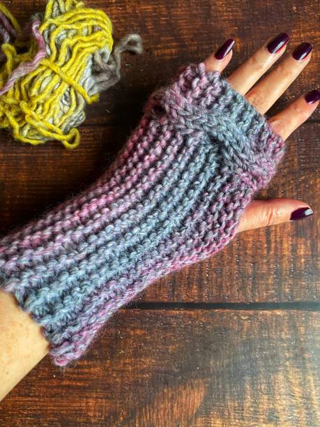istock Woman’s hand wearing a hand knit fingerless mitten 1364606899
