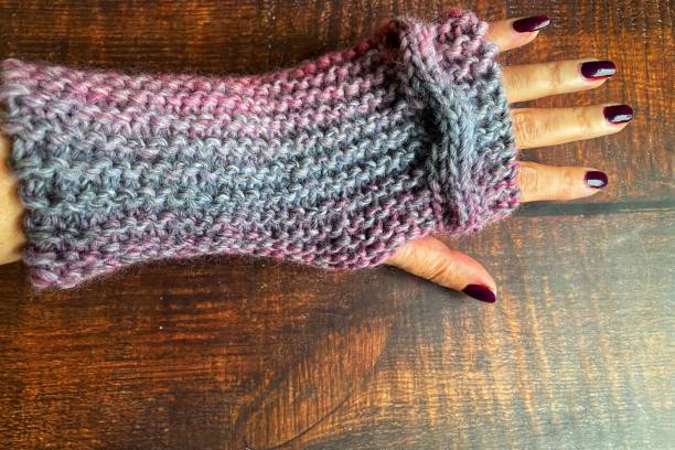 istock Woman’s hand wearing a hand knit fingerless mitten 1364606928