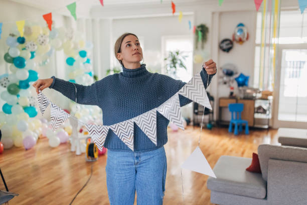 istock Young  decorator hanging party flags and preparing room for celebration 1364608009