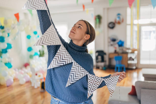 istock Young  decorator hanging party flags and preparing room for celebration 1364608056
