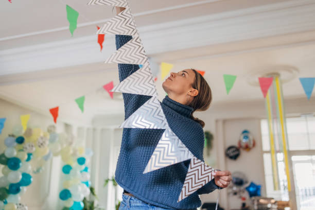 Young  decorator hanging party flags and preparing room for celebration
