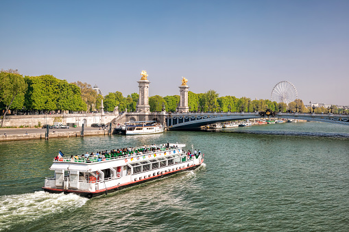 City of Paris with tourist boat close the bridge on Seine river during spring time in Paris, France