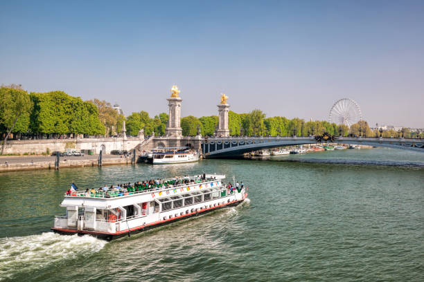 City of Paris with tourist boat close the bridge on Seine river during spring time in Paris, France City of Paris with tourist boat close the bridge on Seine river during spring time in Paris, France seine river photos stock pictures, royalty-free photos & images