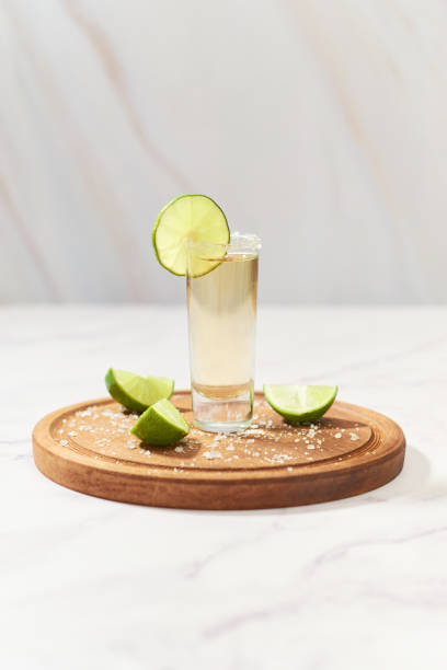tequila shot sur planche de bois. boisson alcoolisée mexicaine. - tequila frappée photos et images de collection