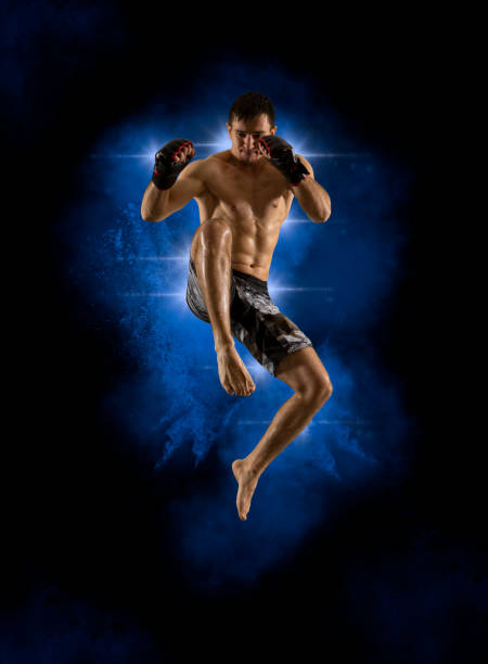 luchador de mma saltando con una patada de rodilla - mixed martial arts combative sport boxing kicking fotografías e imágenes de stock