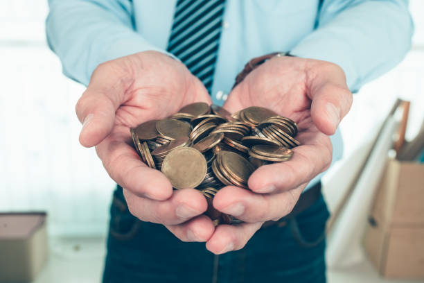 istock coins in businessman hands. Saving money concept. 1364615531