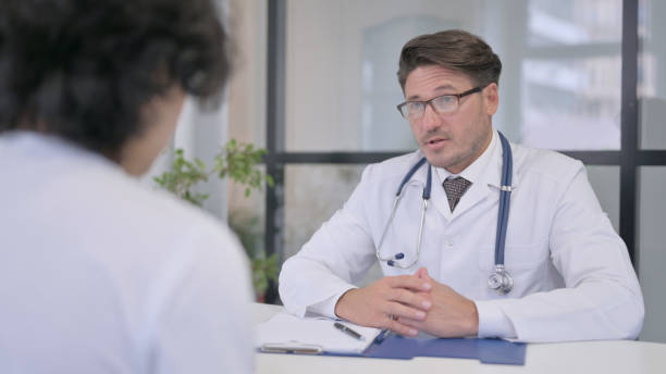 istock Doctor Talking to Patient in Clinic 1364616736
