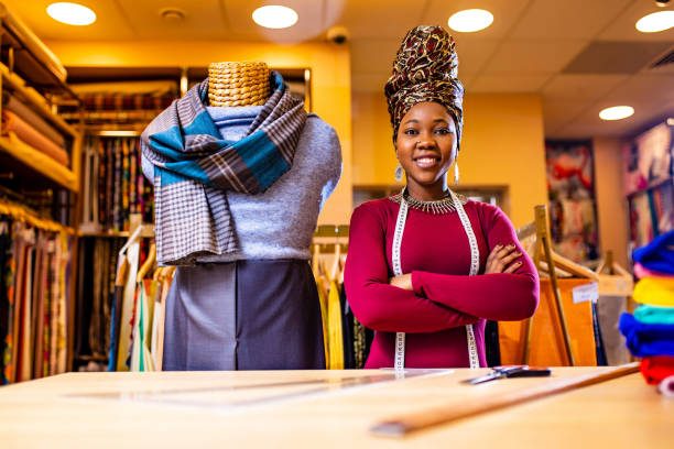 auténtica vendedora étnica áfrica américa trabajando en la tienda - tienda de telas fotografías e imágenes de stock