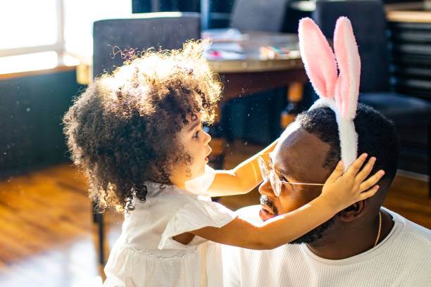 authentic ethnic multicultural people wearing bunny ears in living room day sunlight - family american culture african culture black imagens e fotografias de stock