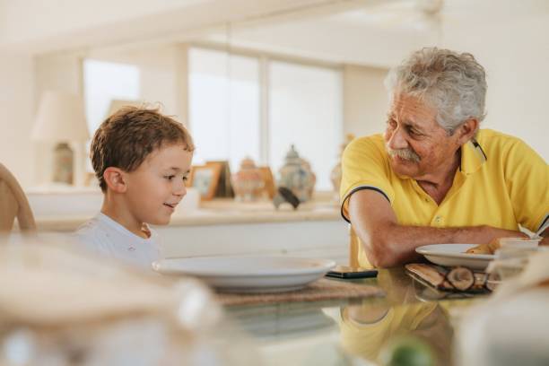 dziadek jedzący obiad z wnukiem - dining table child grandparent grandchild zdjęcia i obrazy z banku zdjęć