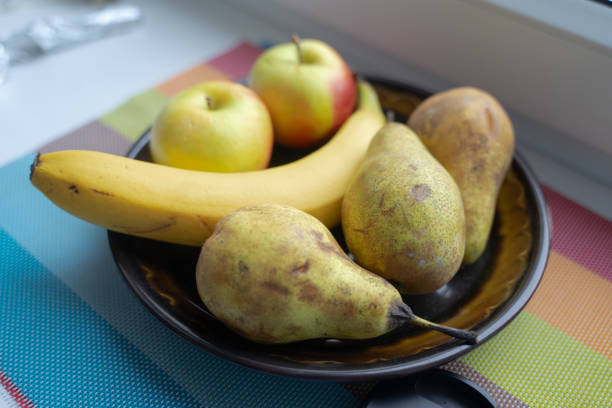 fruits lie in a cup, pears, banana and apples