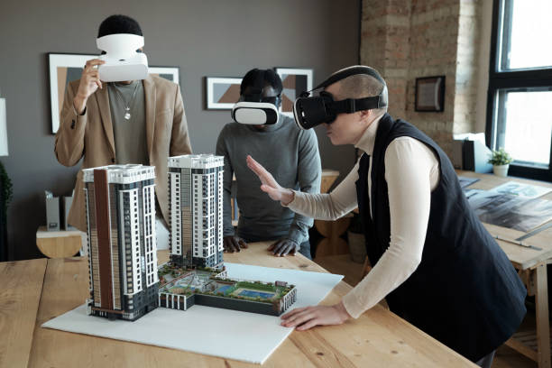 istock Group of three architects in vr headsets standing by workplace 1364621628