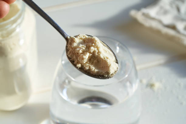 istock Hand holding whey protein powder on a spoon above a table in sunlight 1364627561