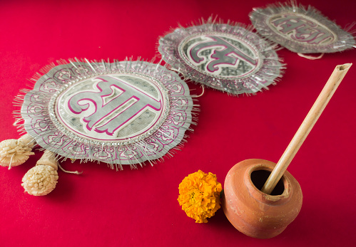 bengali hindu festival saraswati puja and vasant panchami. symbolic concept with copy space. ink pot made of clay, stick pen, marigold flower and chandmala for offering to the goddess of education.