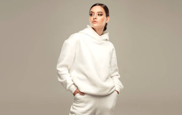 White hoody and sport pants on the perfectly looking young woman wearing in splendid makeup. Fashion and sport. stock photo
