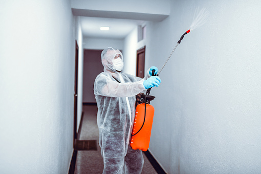 Desinfección de pasillos por un médico experto en traje protector photo