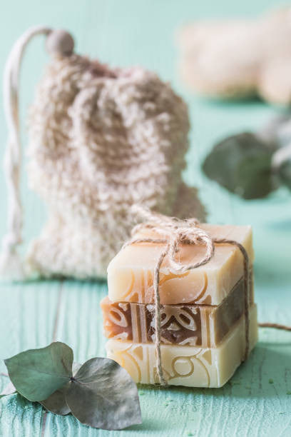 istock Three pieces of natural soap with eucalyptus branches on light green background, wellness concept, vertical 1364633634