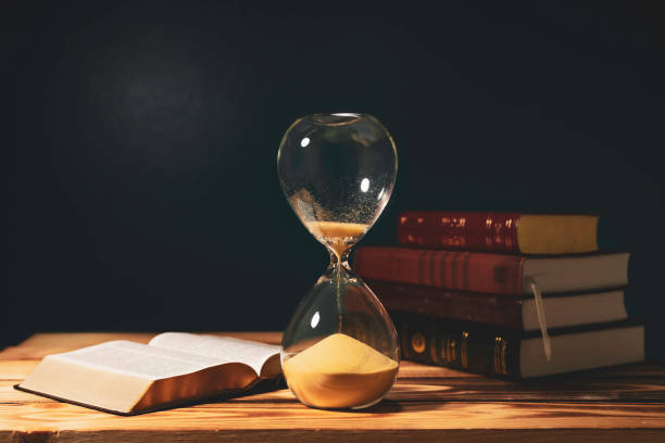 istock Vintage hourglass with open Bible 1364633934