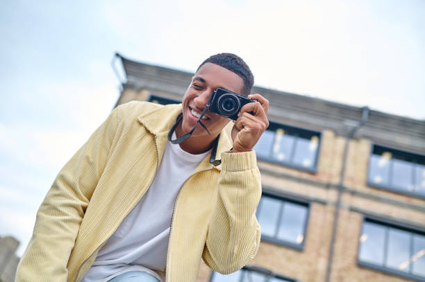 istock Man looking through camera lens outdoors 1364634677