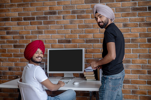 Dos hombres indios trabajando juntos y luciendo contentos photo