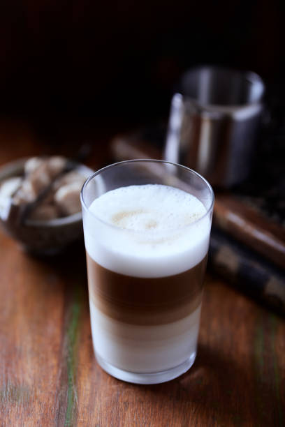 two clear glasses of latte macchiato coffee on white background