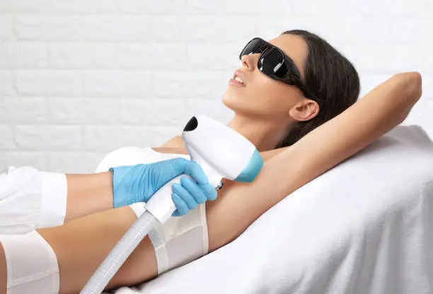 Elos epilation hair removal procedure on a woman"u2019s body. Beautician doing laser rejuvenation in a beauty salon. Removing unwanted body hair. Hardware ipl cosmetology